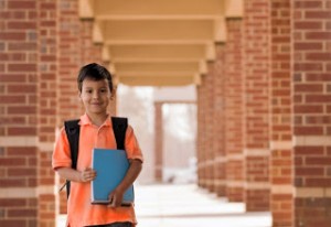 boy with book in school courtyard